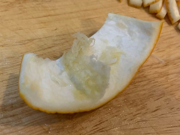 切柳丁皮前在刮乾淨果膜。