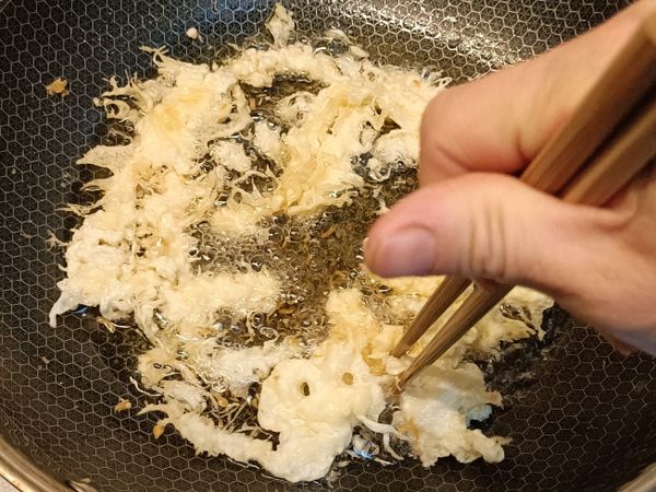 把炸的蛋粉酥用筷子挾到鍋邊，再用筷子把它挾斷成小塊狀，煎熟兩面成金黃色，可拿另一個濾網過濾多餘的油，油瀝越乾越好，起鍋備用（可先用一張濾油紙擺盤上,把炸好的蛋粉酥倒入盤濾油）