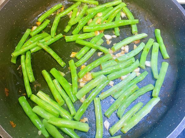 蒜末炒香後再全部拌炒在一起，炒至四季豆熟。