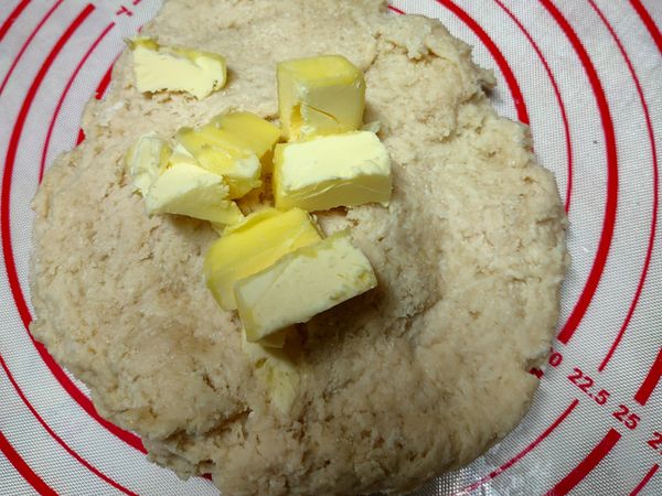 這時麵糰有點粗糙，，再把奶油塊慢慢揉進麵糰