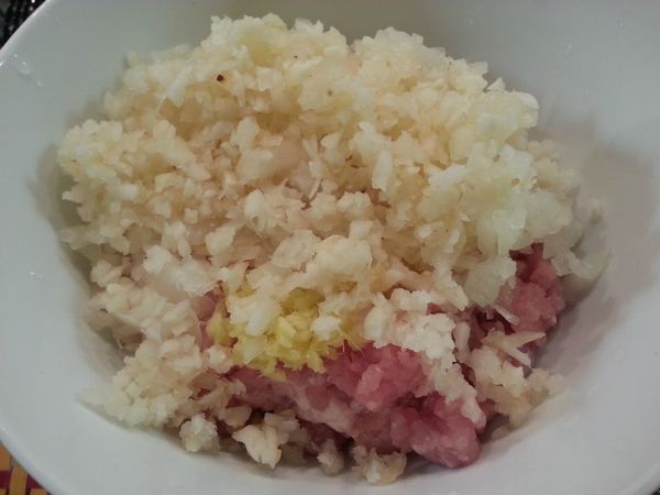 豬絞肉放入碗，然後加入洋蔥、馬蹄和薑。