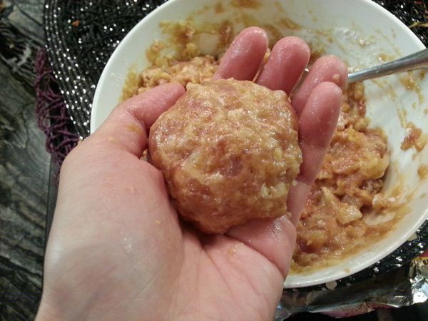 取適量攪拌好的豬絞肉用雙手拋捏成圓形球狀。大小是沒有限定的，我這裡做是大約5cm。