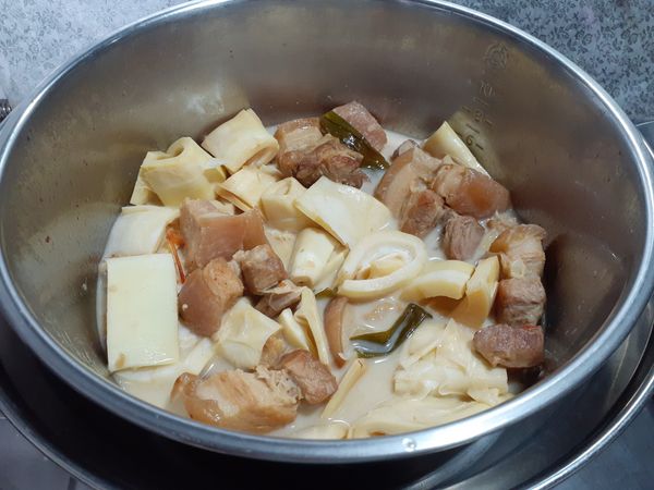 開關再一次跳起後，把筍子和肉拌一拌，讓筍子也沾到湯汁。
倒半杯水到外鍋，在悶煮一下，開關跳起後悶一下再掀開。