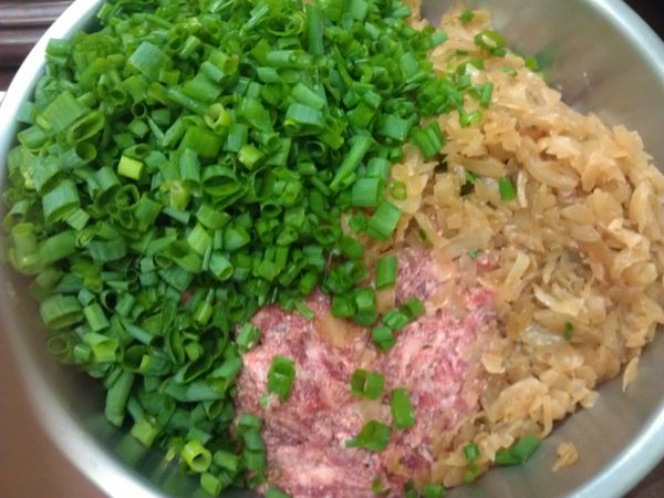青蔥切蔥花。洋蔥切丁入鍋炒軟至甜味溢出，放涼備用。將牛、豬絞肉和所有[調味料]拌打均勻至有黏性後放入冰箱1小時入味。