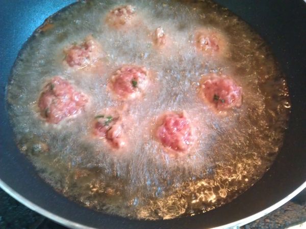 熱油鍋至放入木筷子會有小泡產生，轉中小火，用左手虎口捏出肉丸子，右手拿湯匙將肉丸子舀入油鍋中，先不要馬上翻動，以免破壞丸子的形狀。