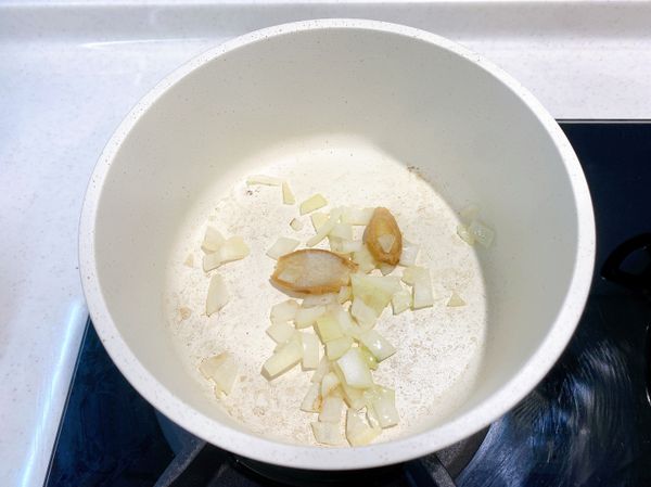 熱鍋後放入1匙食用油，轉小火、加入洋蔥丁及薑片爆香。