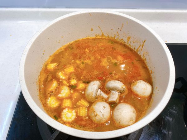 加入600ml的水、撕開調理包、調味粉包、調味油包並加入，接著放入馬鈴薯、洋菇、玉米筍，繼續燉煮10分鐘。