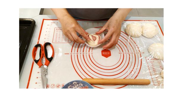 麵糰捍平, 放入火腿片捲起, 捏緊收口對摺剪開, 放入紙模中.