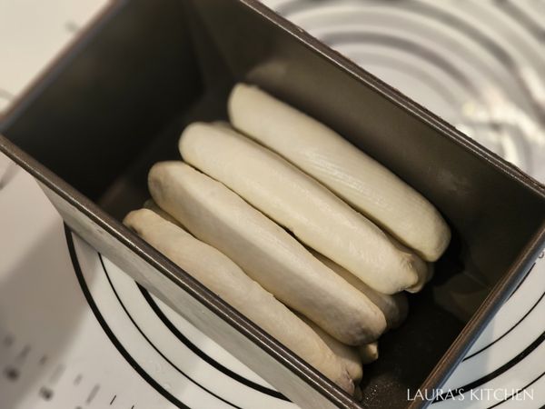 將包好的長條放入12兩吐司模，第一層4條、第二層3條、最上層4條。把吐司模放進發酵箱中，我用的是有發酵功能的烤箱，但發酵過程很乾燥，建議加上吐司上蓋，進行二次發酵至九分滿。註: 發酵時間會因溫度、濕度不同而異，請自行調整 (參考時間: 80分鐘)