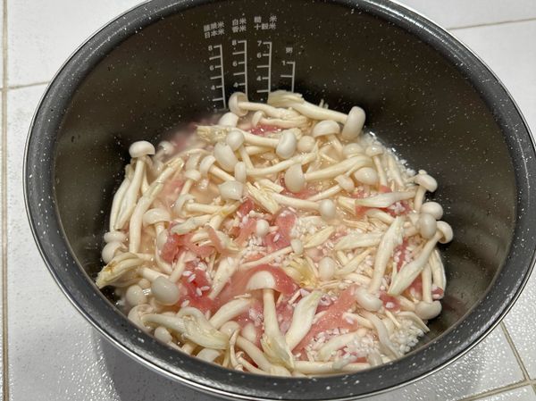 倒入1:0.8的水(1杯米/0.8杯水)因為雪白菇會出水所以水量放比較少許，再將肉絲與雪白菇放入均勻攪拌後放入電子鍋用「香米」模式炊煮