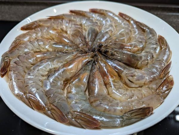 白蝦洗淨，剪去蝦頭上的尖刺、蝦頭前端觸角、蝦鬚及蝦腳，開背去除腸泥，稍微沖洗後再擺入盤中。