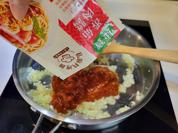 倒入肉醬包加點水煮開後關火。