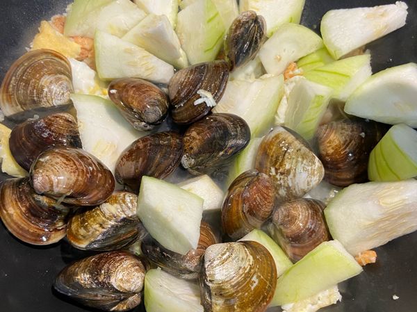 放入蛤蜊、絲瓜、1/3米杯水大火拌炒