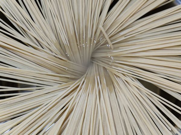 煮一鍋水，水半滾時將義大利麵條以放射狀放入鍋中。
方式是將一整束麵條放在中央，扭轉90度後鬆手，麵條就會以傘狀散開，這種煮法可以讓每根麵條不重疊，容易熟，不沾黏。