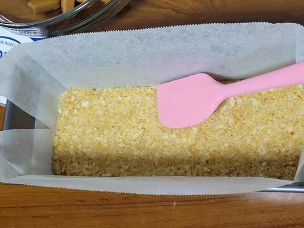 無鹽奶油拌入餅乾混合均勻後倒入模型中，
以刮刀壓實壓平後連同模型放入冷藏15分鐘以上。