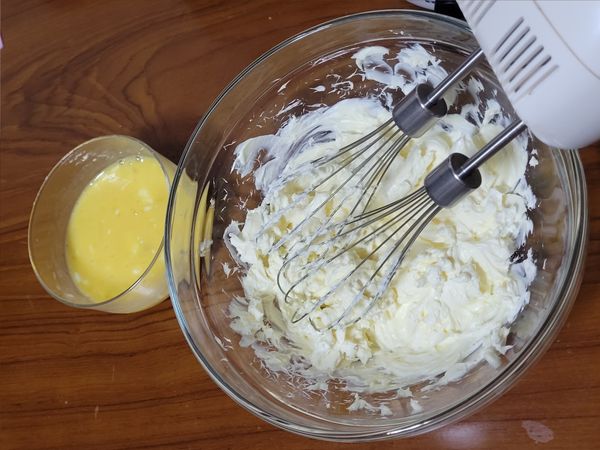 兩顆雞蛋打散後分數次加入奶油乳酪攪拌均勻。