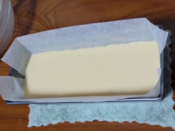 將完成的蛋糕糊倒入模型中，輕震出氣泡。