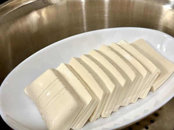 嫩豆腐切片，放入大同電鍋，1/4杯水蒸至跳起。