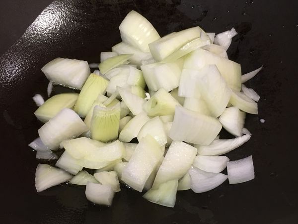 起油鍋拌炒洋蔥塊。