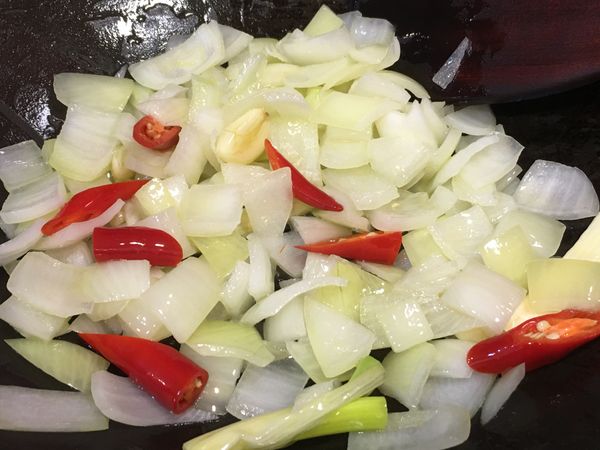 洋蔥炒至透明後加入辣椒段、蒜頭、蔥白拌炒。