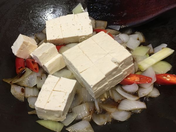 炒至蒜味、辣椒香氣釋出後沿鍋邊加入紅燒醬汁，再加入豆腐塊。
註：醬油觸鍋高溫下會逼出醬油焦香氣。