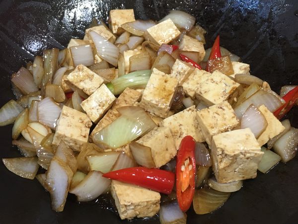 將豆腐、食材與醬汁翻拌均勻，蓋上鍋蓋以小火煨煮5分鐘，中途開蓋再次翻拌確認每塊豆腐都有吸附到醬汁。
註：洋蔥與豆腐在煨煮過程中會再出水，所以一開始的水量不用加太多。