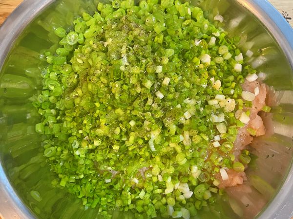 將四季豆和蔥花都放到切好的雞胸肉上，放調味料；