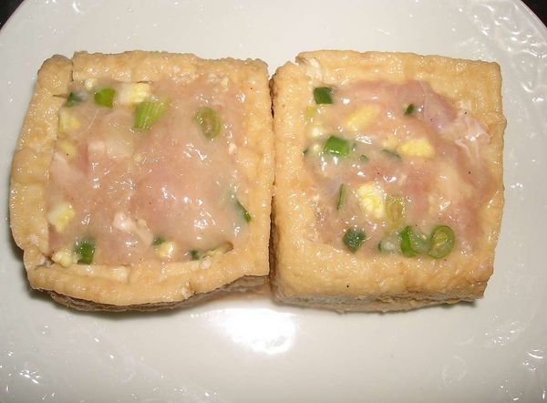 取二塊油豆腐，中間挖空，塞入一部份的雞泥，中間放入起司片，最後再裏上雞泥收尾即可備用...