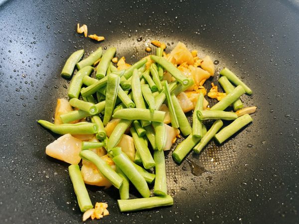 加入四季豆拌炒，加入醬鹽和黑胡椒粒調味