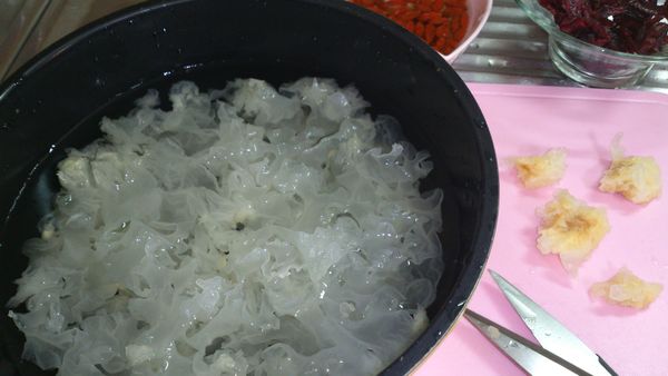 雪耳泡水二十分鐘後,將黃色蒂頭剪去,洗淨剪碎成小朵狀,瀝乾備用