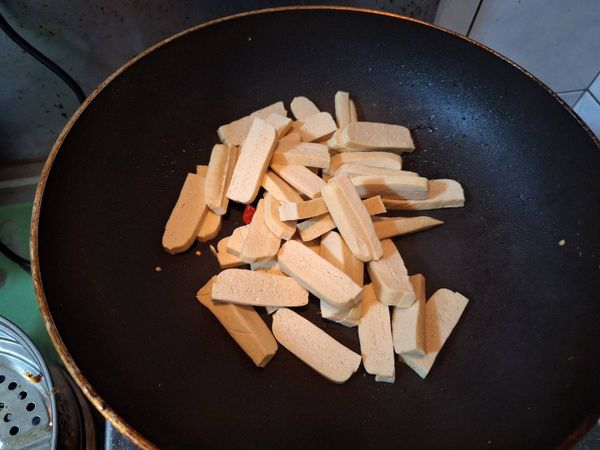 辣椒香氣出來後，放入切片豆干，翻炒10下左右後
倒入1.5碗水和1匙醬油，持續續翻炒10下後
蓋鍋蓋悶2分鐘