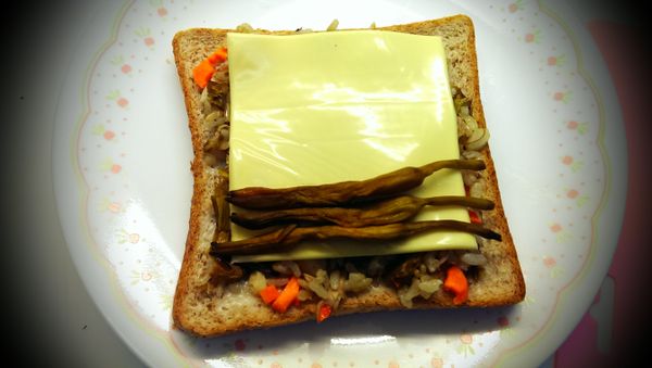 起司片上放上原色金針後捲起切片排盤後再放上埤南洛神花裝飾