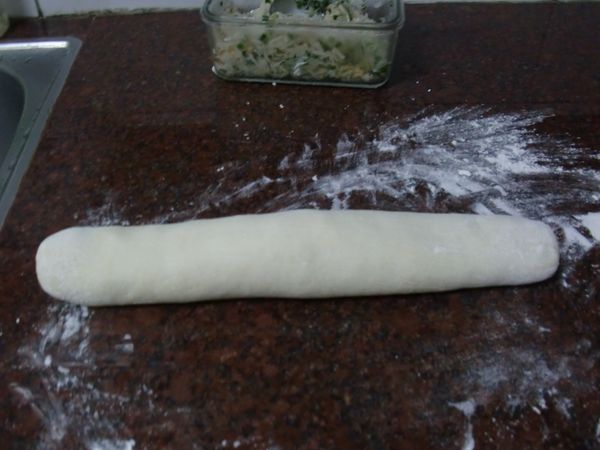 將麵團搓揉成長條，切成十等份。把每份麵團壓平桿成大園片，包入內餡，收口處捏緊並壓成扁圓形。