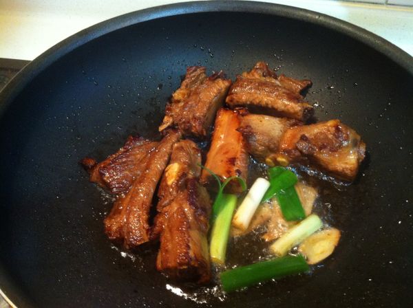 中小火起油鍋,倒入葵花油,放入作法3的豬小排煎炸至赤赤,即可放入[調味料]及[醃料],蓋上鍋蓋轉小火悶煮..