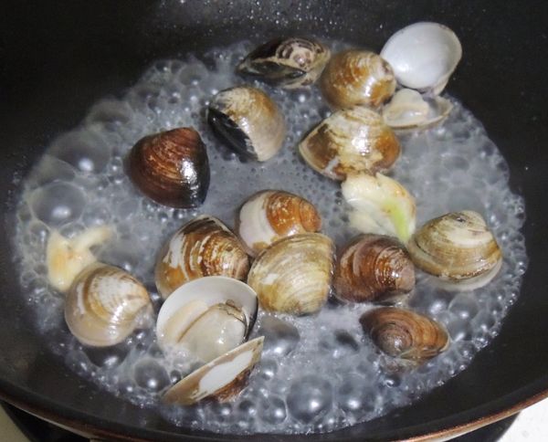 然後放入蛤蜊,並加上適量的38度金門高梁酒.

請務必留意高梁酒可能會燃燒,必要時可以加上鍋蓋...