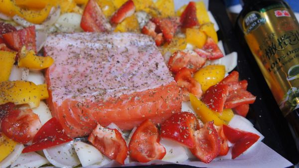 在烤盤上，鋪上烘焙紙，先在中間倒約一茶匙的泰山橄欖油，將鮭魚放上，這是避免鮭魚黏紙。
在鮭魚的四周依序放上洋蔥及甜椒。
在鮭魚及菜上均勻的撒上玫瑰鹽及義大利香料粉。