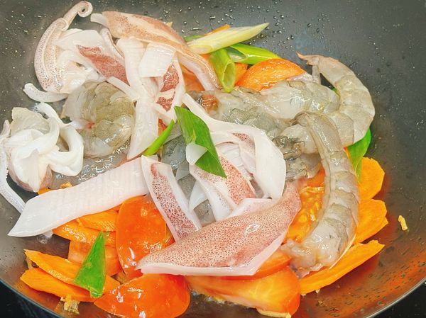 蝦子和花枝接著下鍋，炒到蝦子略紅，沿著鍋邊嗆一些米酒增加香氣，也能去海鮮的腥味。