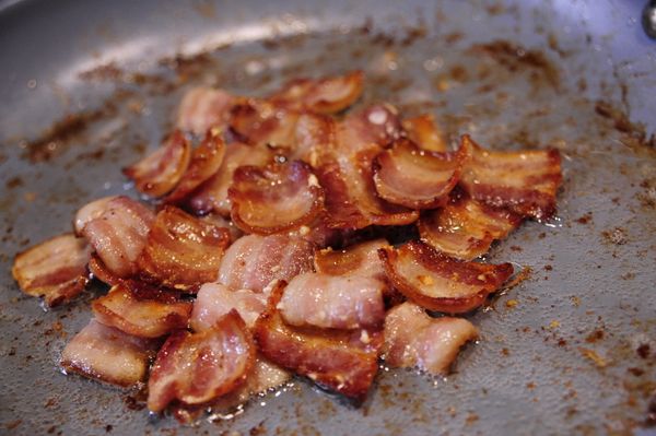 培根切成丁小片後以中火將油逼出，油留在炒鍋內。