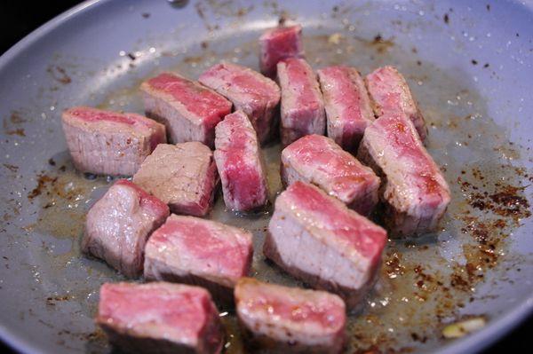 利用炒鍋內的培根油脂並將牛肉塊夾入，以中大火持續翻轉牛肉塊，這時可撒上少許鹽與胡椒調味，這步驟只需將牛肉外表煎熟鎖住水份即可勿過度，同樣將牛肉塊夾出放進培根的燉鍋內。