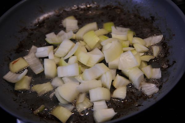 同一個炒鍋放入洋蔥丁以中火翻炒，如此時炒鍋內油量不足可補充少量橄欖油，洋蔥大約翻炒5分鐘後加入洋菇炒軟，再加入大蒜末翻炒約1~2分鐘即可。