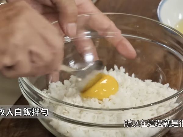 培根切丁備用，打一顆蛋把蛋黃放進白飯中拌勻備用