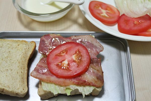 好！開始組合了…先將土司的一面塗抹調好步驟３醬汁，再依序放上生菜、培根、蕃茄、醬汁、土司、生菜、雞胸肉、蕃茄、醬汁以及土司這樣就完成了。