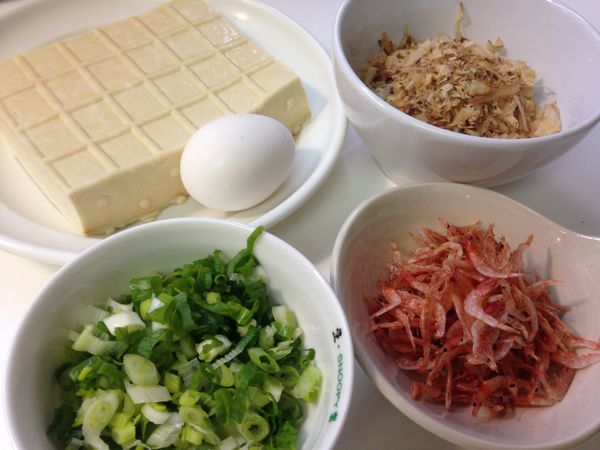 備料。板豆腐先用廚房紙巾將水份吸乾後，表面較硬的豆腐皮去除((可以用來煮湯))後，用刀背壓成泥。