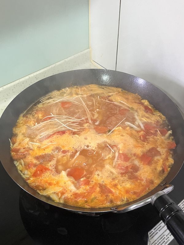 後加入1公升的水(或高湯)，大火煮開後加入兩把細麵，煮至細麵8分熟，加入適量食鹽