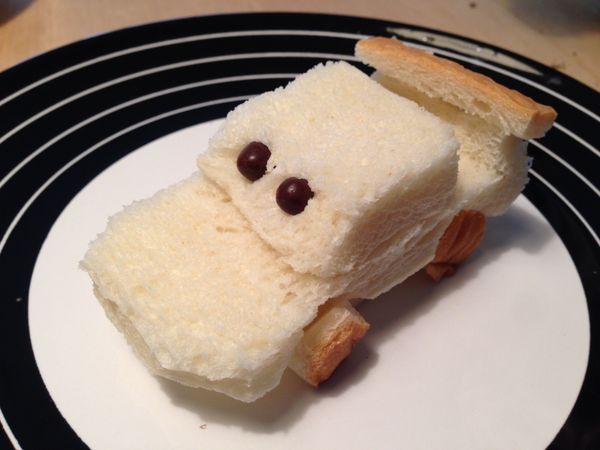 將之前的吐司邊剪四個小車輪,然後在上面的方形旁用筷子鑽二個洞,塞入二個巧克力米果,整個跟兒子一起疊起來,是不是就有閃電麥坤的樣子了!