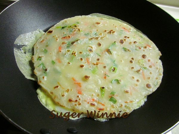 平底鍋放油,油有些熱度後舀麵糊在中間,稍微搖晃鍋身,讓麵糊流往四周(可先放一滴麵糊測試,馬上凝結表示可下鍋),麵糊煎至金黃色再翻面續煎,一樣煎到金黃色後起鍋,原鍋加油煎蛋,趁蛋未凝固時把煎好的餅皮放上去,蛋熟即可關火