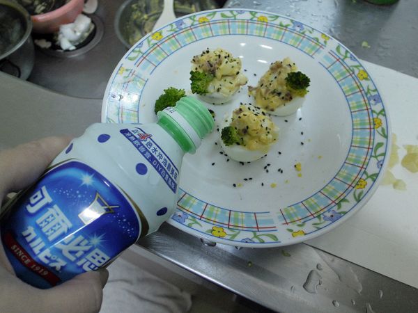 把拌好的蛋沙拉放入雞蛋杯裡，灑上巴西里末、熟黑芝麻，再倒入少許的可爾必思乳酸菌發酵乳為沾醬。