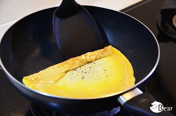 先將平底鍋抹上一成薄薄的油並開中小火，倒入蛋液後待一面略熟時，從一邊慢慢捲起來。