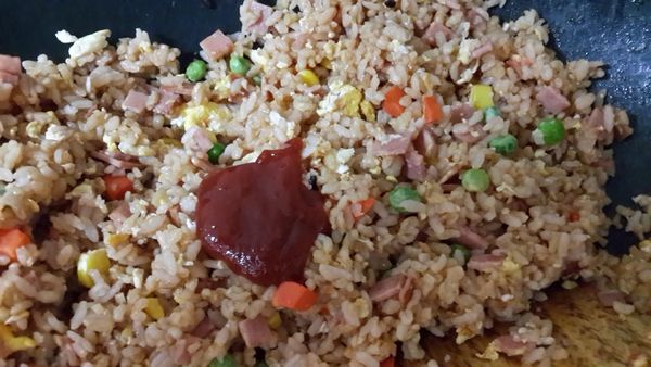 倒入飯拌炒再加入番茄醬拌勻
將飯炒散,
最後醬油從鍋邊嗆鍋加入增加香氣~完成