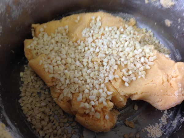 將麵粉和泡打粉篩入後拌成麵糰，並加入杏仁角粒。